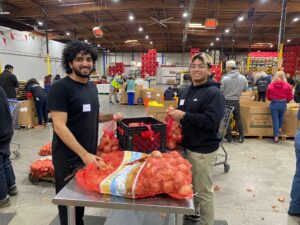 ITD employees smiling while they sort through a bag of onions